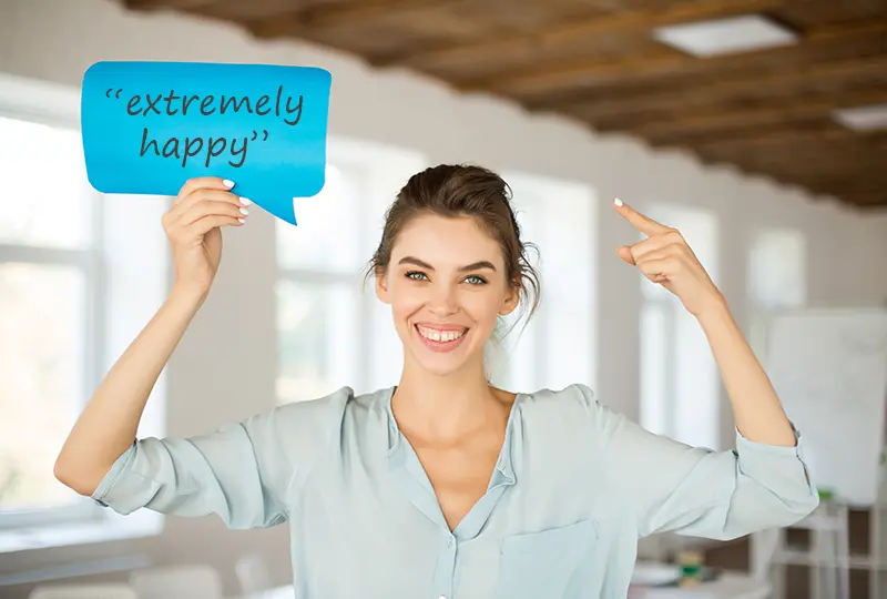 happy woman holding up a sign that says extremely happy (an excerpt from a testimonial about CJ Creative Design)