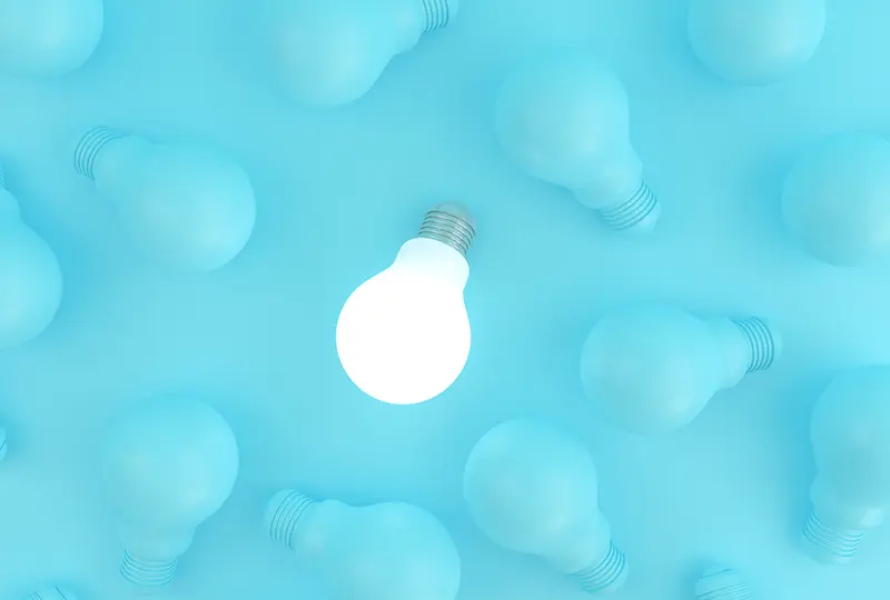 lightbulb-insights lit lightbulb among several unlit bulbs on a light teal background