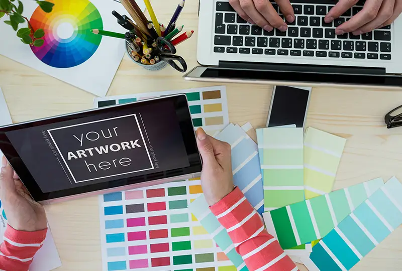 desk with color swatches and two people working on branding choices